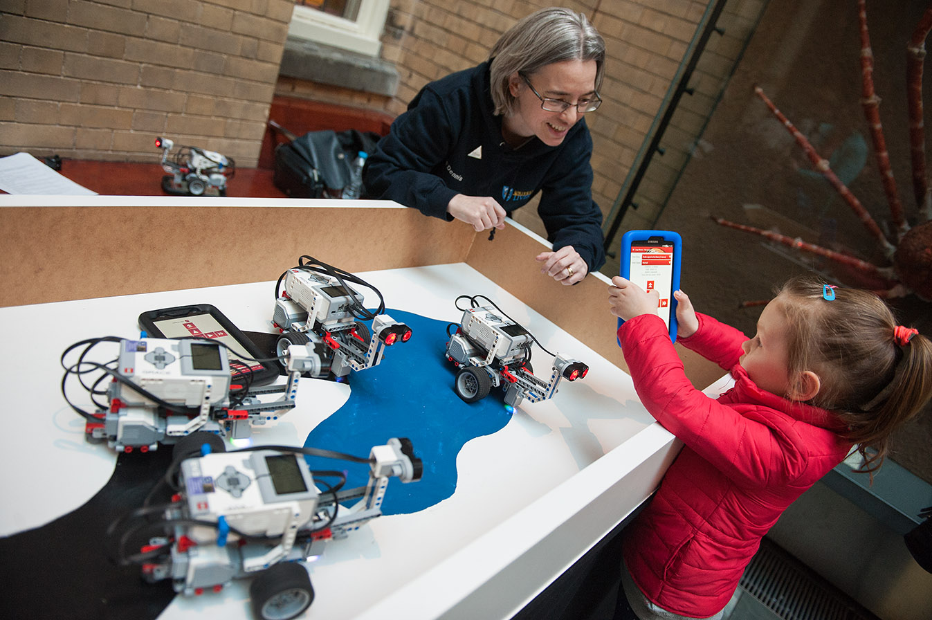 Photo of Dr. Dennis, a little girl and a Lego Robot.  Photo credit Max Alexander/UK Spac Agency.